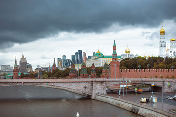 View of the kremlin's part in and the Great zamoskvoretsky bridge with traffic from cars in cloudy weather.