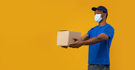 Wall Mural - African american delivery guy in medical mask giving cardboard box