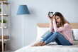 © BestForYou - Sad woman holding alarm clock on the bed