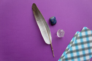 Wall Mural - tarot cards deck with natural mineral stones and feather top view esoteric purple background