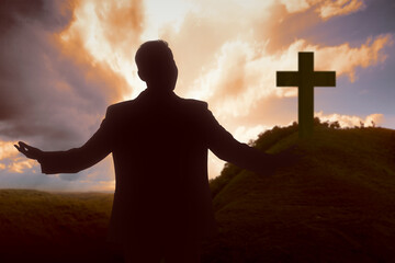 Silhouette of businessman raised hands and praying to god