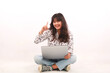 © faishalabdula - Portrait of an excited young beautiful girl holding laptop computer and celebrating success isolated over white background.