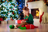 Fototapeta Na ścianę - Kids at Christmas tree. Children open presents