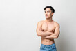 © Atstock Productions - Portrait of handsome shirtless Asian man looking at the side with arms crossed in isolated studio light gray background