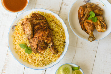 Poster - Arabic chicken Manthi or mandi cooked meat, Basmati rice with Masala, spice. Kuzhimanthi or hot and spicy Manthi on black background in Malabar Kerala, South India. Top view of Indian non veg food.