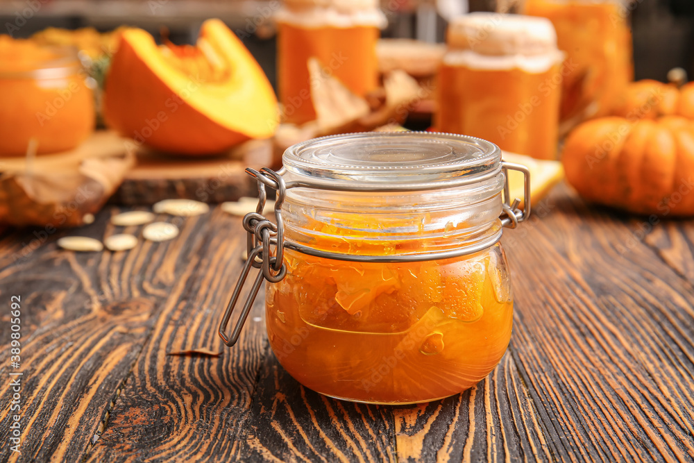 Jar of tasty pumpkin jam on table