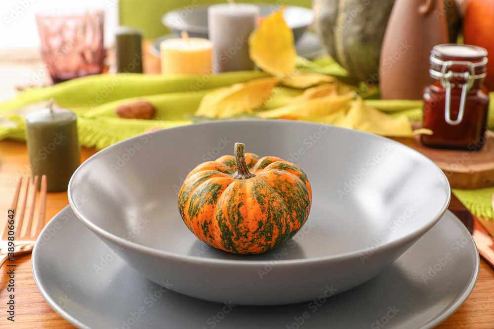 Beautiful table setting with pumpkin in dining room