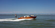 © Peter Henry Tucker/Wirestock - VENICE, ITALY - Jun 19, 2018: A water taxi travels across the lagoon on a sunny day  in Venice, Italy