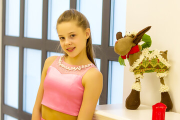 Wall Mural - Pretty Teenage Girl Posing in Room with Reindeer Toy