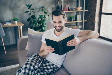 Wall Mural - Photo of domestic homey handsome guy stay home quarantine time reader book worm good mood sit comfy cozy sofa modern interior flat living room apartments indoors