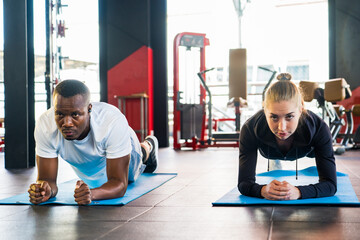 Wall Mural - Athlete sporty muscular man and woman doing planking in fitness gym