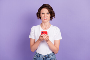 Poster - Photo portrait of disapointed irritated girl keeping mobile phone misunderstanding put dislike isolated on bright violet color background