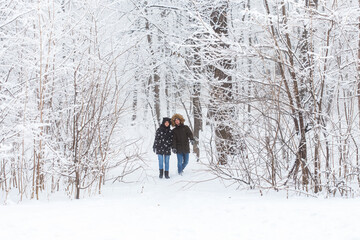 Happy loving couple having fun outdoors in snow park. Winter vacation