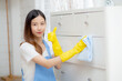 Young asian woman in gloves cleaning home in room, housekeeper is wipe with fabric, housemaid and service, worker polish dust at living room in house, housework and domestic, lifestyle concept.