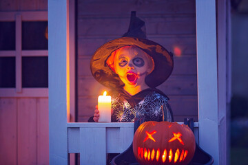 Canvas Print - Scary toddler child in halloween costume, playing with carved pumpkins