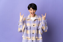 Woman With Short Hair Isolated On Purple Background Making Horn Gesture