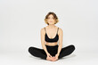 © SHOTPRIME STUDIO - Woman in leggings meditate in a light room with her legs crossed yoga asana