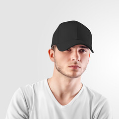 Wall Mural - Mockup of a black baseball cap on a guy's head, front view, isolated on background.