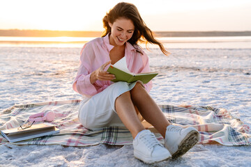 Smiling beautiful young woman reading a book