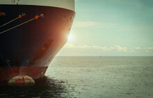 Retro Filter Tone Of Cargo Ship Moored Bollard With A Fixed Rope On The Front Of Bulbous Bow Ship Logistics And Transportation Of International Container Cargo Ship In The Sea On Sunset.
