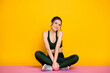 © deagreez - Portrait of pretty sportive cheerful shy girl doing class mat work studio isolated on bright yellow color background