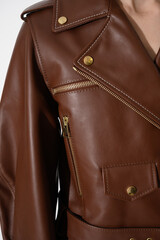 Wall Mural - Brown leather jacket with metal zippers on it. Girl in a stylish white jacket. Stitched leather. Closeup. Vertical fashion background.