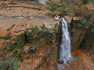 Wall Mural - man with woman holding usa flag on the top of the waterfall