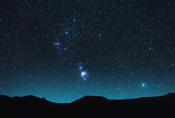 Wall Mural - beautiful orion nebula on the starry sky over the hill silhouette. night photography astronomical wa