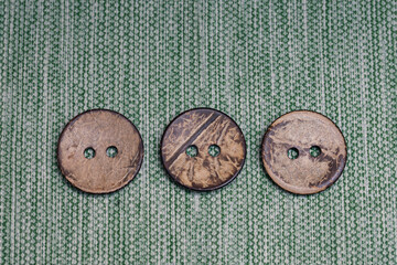 Three large old buttons made of wood on canvas from my grandmother's box. Vintage items for creativity and needlework.