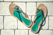 Colorful sandals on the terrace with tile floor in the summer sun