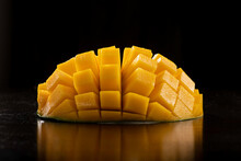 Ripe Sliced Mango On Dark Table Against Black Background
