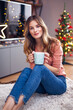 © Gabi Moisa - Beautiful young smiling woman at Christmas drinking a cup of tea