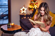 © Gabi Moisa - Beautiful young smiling woman at Christmas reading a book
