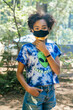 © Inti St. Clair - Portrait of teen girl in forest campground wearing face mask