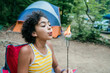 © Inti St. Clair - Teen girl blowing fire off of toasted marshmallows while sitting in campground by campfire