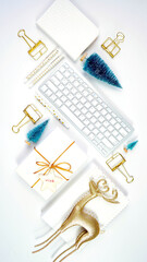 Wall Mural - Christmas shopping desktop in modern gold and white theme with reindeer decoration, keyboard, gift and desktop accessories. Top view blog hero header creative composition flat lay.