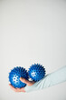 Dwie niebieskie piłki do masażu na kobiecej dłoni