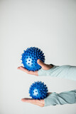 Fototapeta Londyn - Dwie niebieskie piłki do rehabilitacji trzymane na kobiecych rękach. 