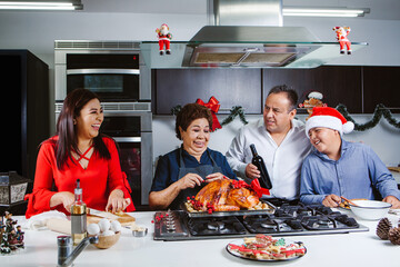 Wall Mural - Latin elderly mom preparing turkey with family on the kitchen in Mexico