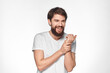 © SHOTPRIME STUDIO - Bearded man in white t-shirt gesture with hands emotions light background