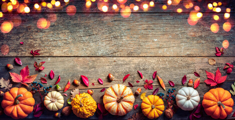 Wall Mural - thanksgiving board - wooden table with pumpkins and lights