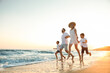 © New Africa - Happy family running on sandy beach near sea at sunset
