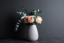 Bouquet Of Beautiful Flowers And Eucalyptus Branches In Vase On Table Against Black Background