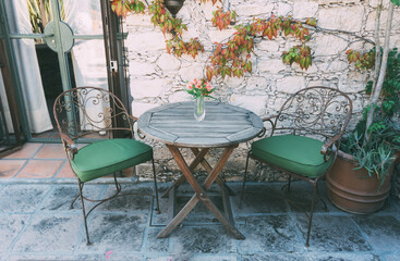 a table with bouquet of flowers and two vintage chairs, vintage design