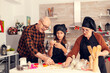 © DC Studio - Granddaughter on christmas day making dessert for santa wearing apron. Happy cheerful joyfull teenage girl helping senior woman preparing sweet cookies to celebrate winter holidays.
