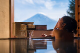 Fototapeta Paryż - Beautiful woman enjoy onsen (mineral hot bath) in morning and seeing view of Fuji mountain in japan