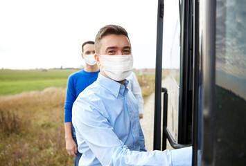 Poster - tourism and health concept concept - group of male passengers boarding travel bus wearing face protective medical mask for protection from virus disease