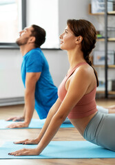 Wall Mural - sport, fitness, lifestyle and people concept - smiling man and woman exercising at home