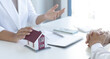 © Puwasit Inyavileart - Home salesman explains the terms of buying a home to customers who need accommodation.