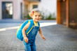 © Irina Schmidt - Cute little adorable toddler girl on her first day going to playschool. Healthy beautiful baby walking to nursery school and kindergarten. Happy child with backpack on the city street, outdoors.